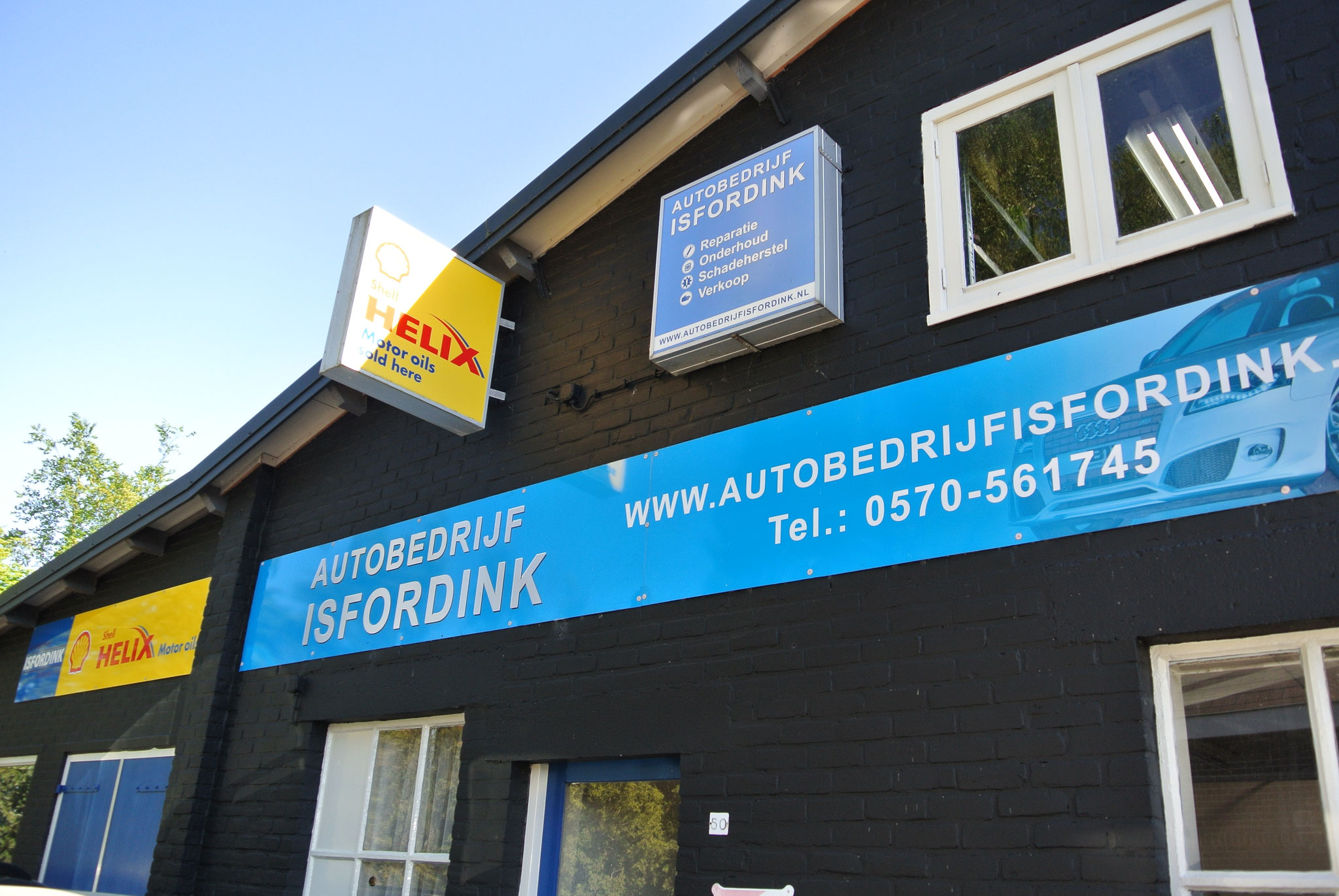 De gevel van het pand met de blauwe naambalk en het Shell Helix-bord