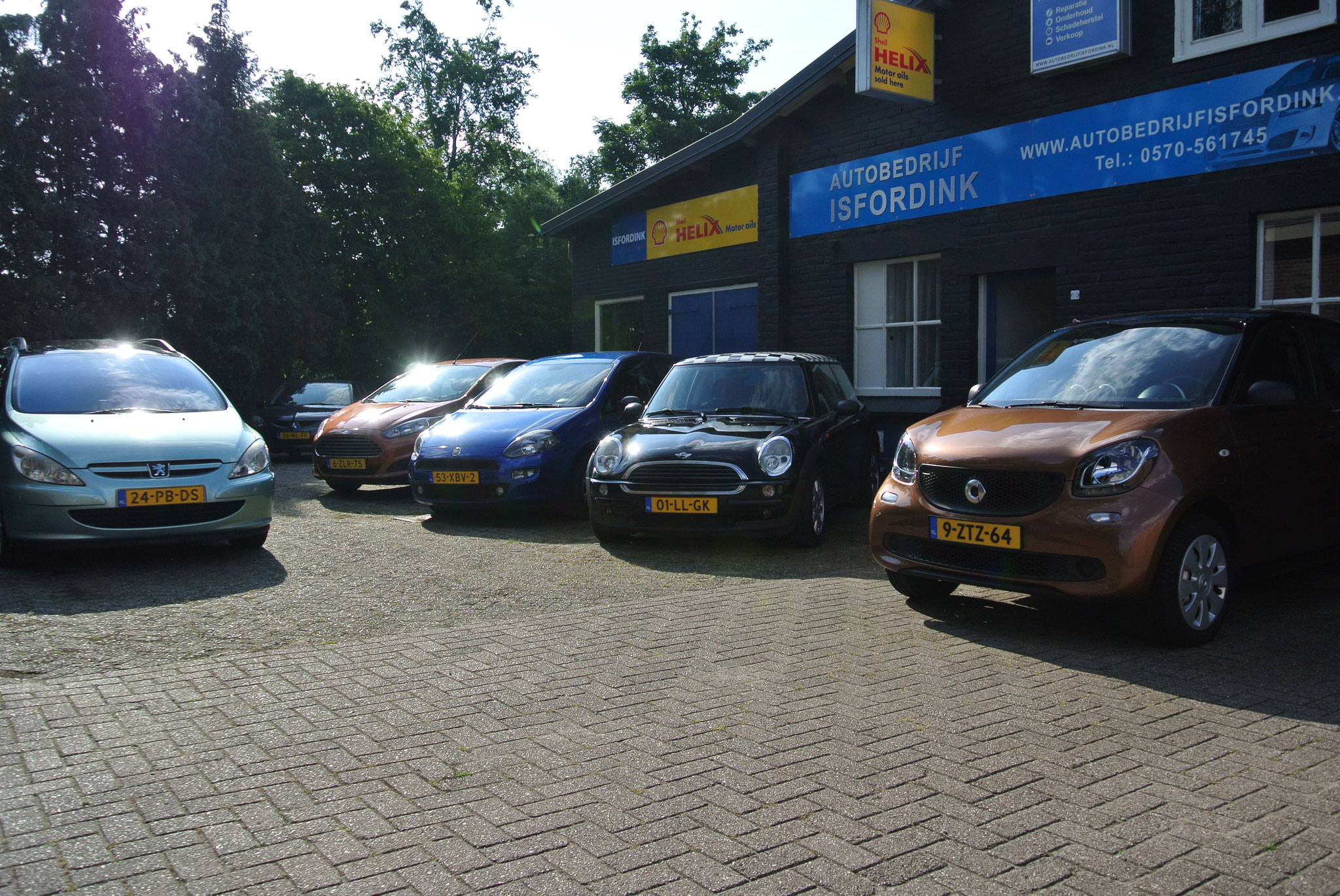 Het terrein aan de Boskamp met een rij auto's voor het pand