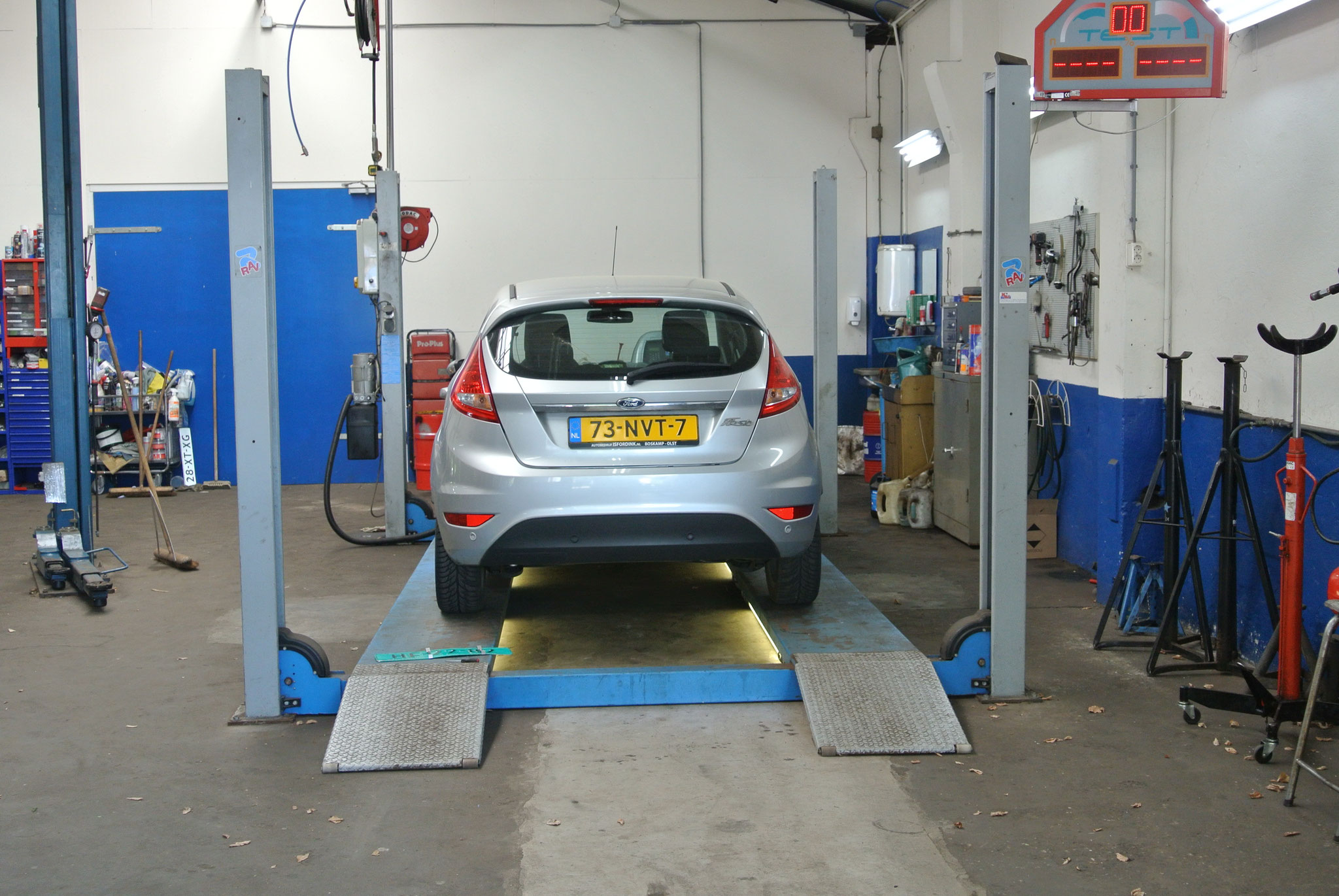 Een Ford Fiesta op de hefbrug in de werkplaats